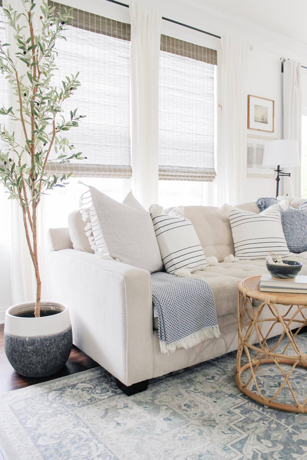 Caitlan Marie Design Sofa A creamy white sofa with four square throw pillows in striped and lightly patterned fabric.