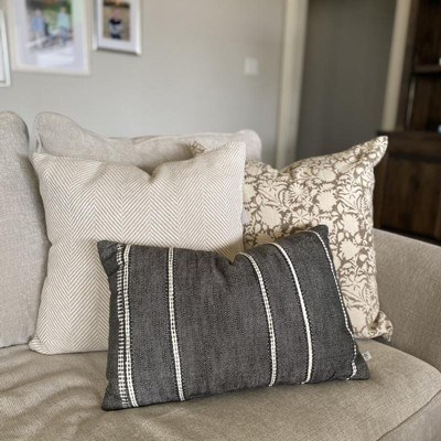 Target pillows Three pillows on the corner of a sofa. All are various gray colors, one has vertical pinstripes, one has a very small herringbone, and the third has a medium sized floral pattern