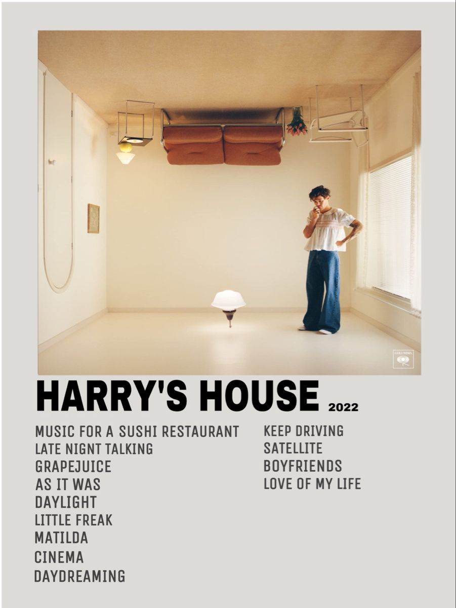 Harry Styles stands in an upside-down room on the Harry’s House album cover, wearing a white top and blue jeans, with furniture attached to the ceiling.