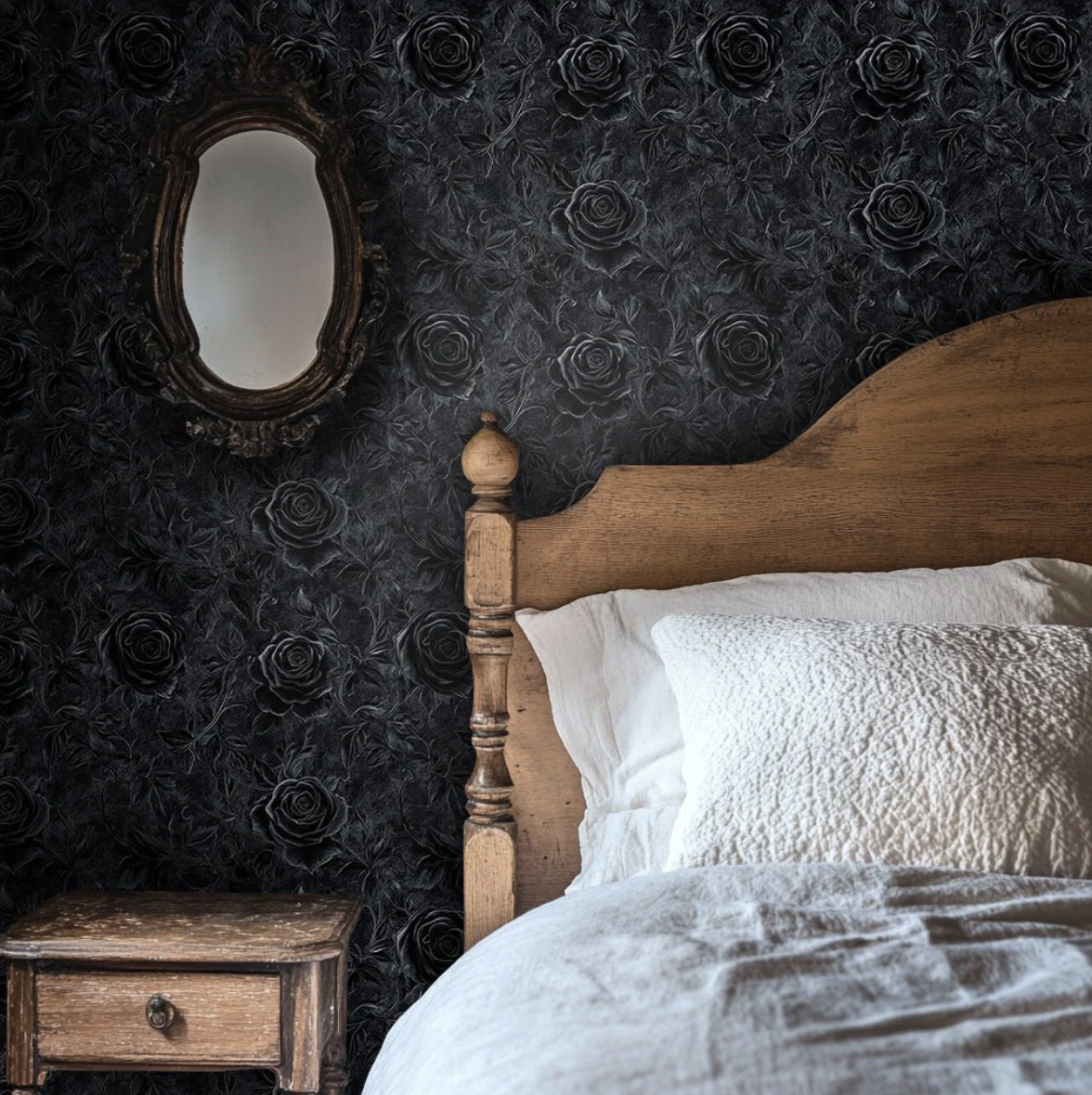 Bedroom with black rose wallpaper, rustic wood bed, white bedding, and an antique mirror, combining dark romantic decor with vintage charm.