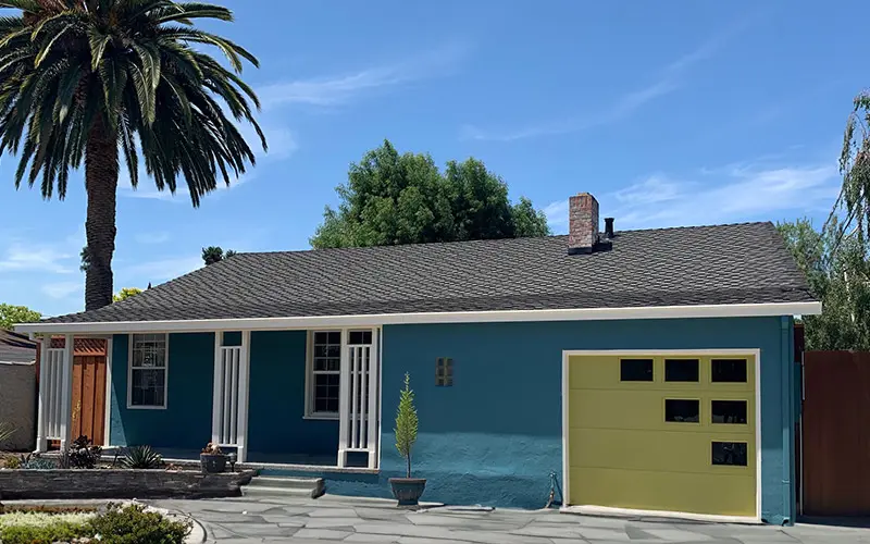 Mid-century home exterior with teal siding and green garage door